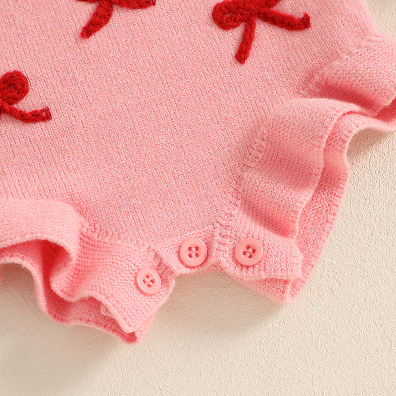 Pink baby romper with red bows on a light background