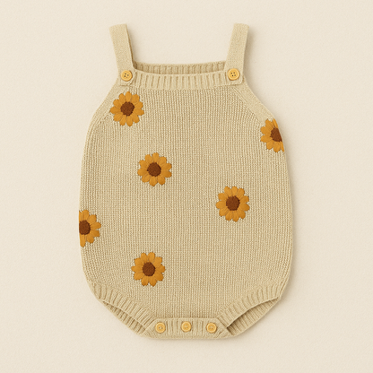 Beige knitted baby romper with sunflower patterns on a beige background